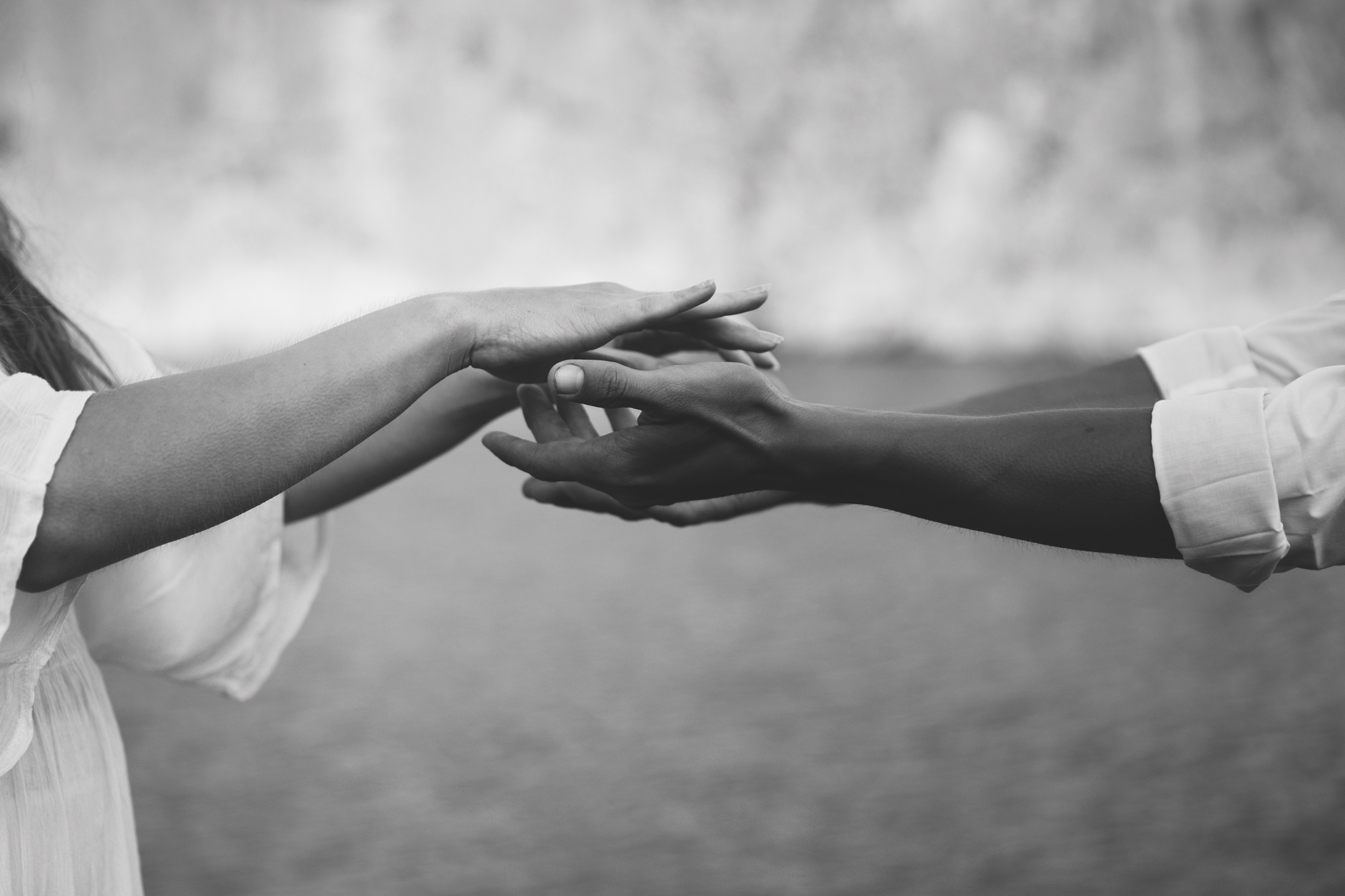 black and white reaching for each others hands 