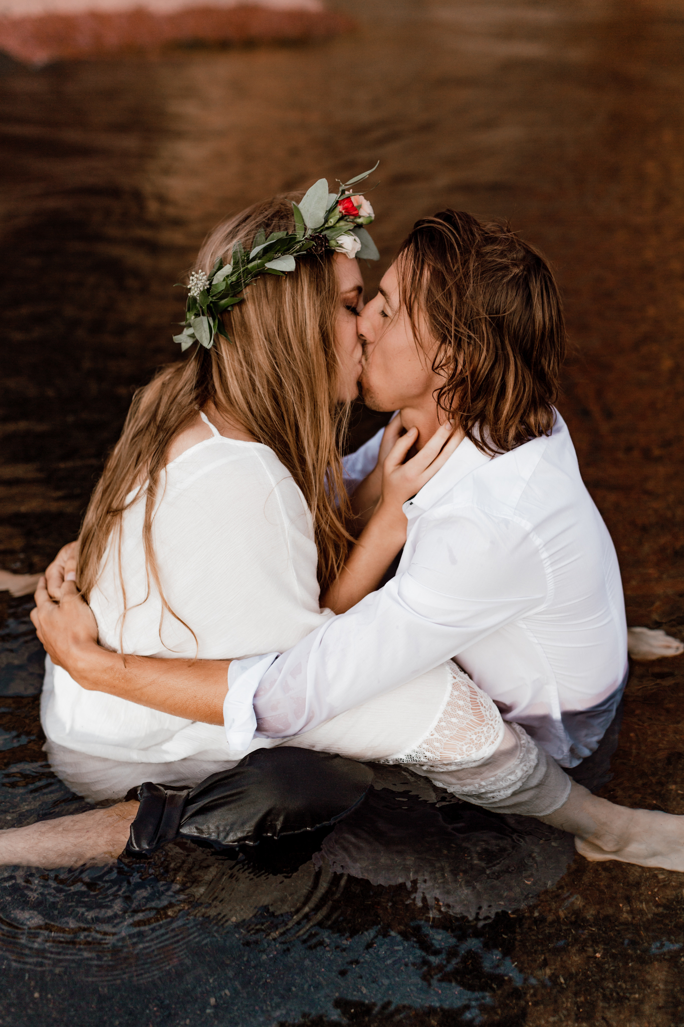 couple kissing facing each other in the water 