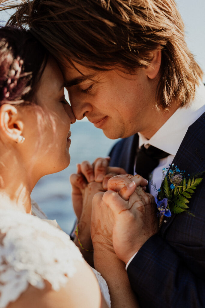 close up image of bride and grooms faces as they hold each others hands 