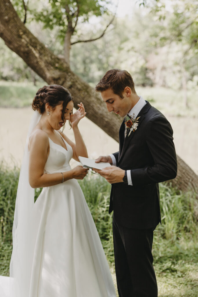 Reading vows privately after first look and bride is wiping away her tears 